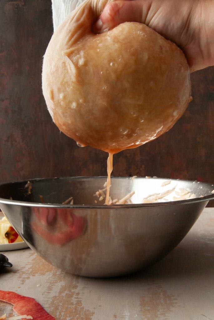 Using a cheesecloth to strain excess liquid from potatoes