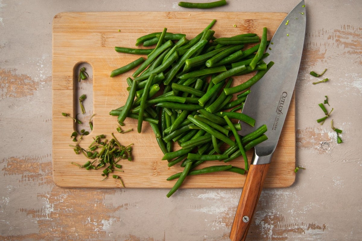 prepping greenbeans by chopping off ends and slicing in half