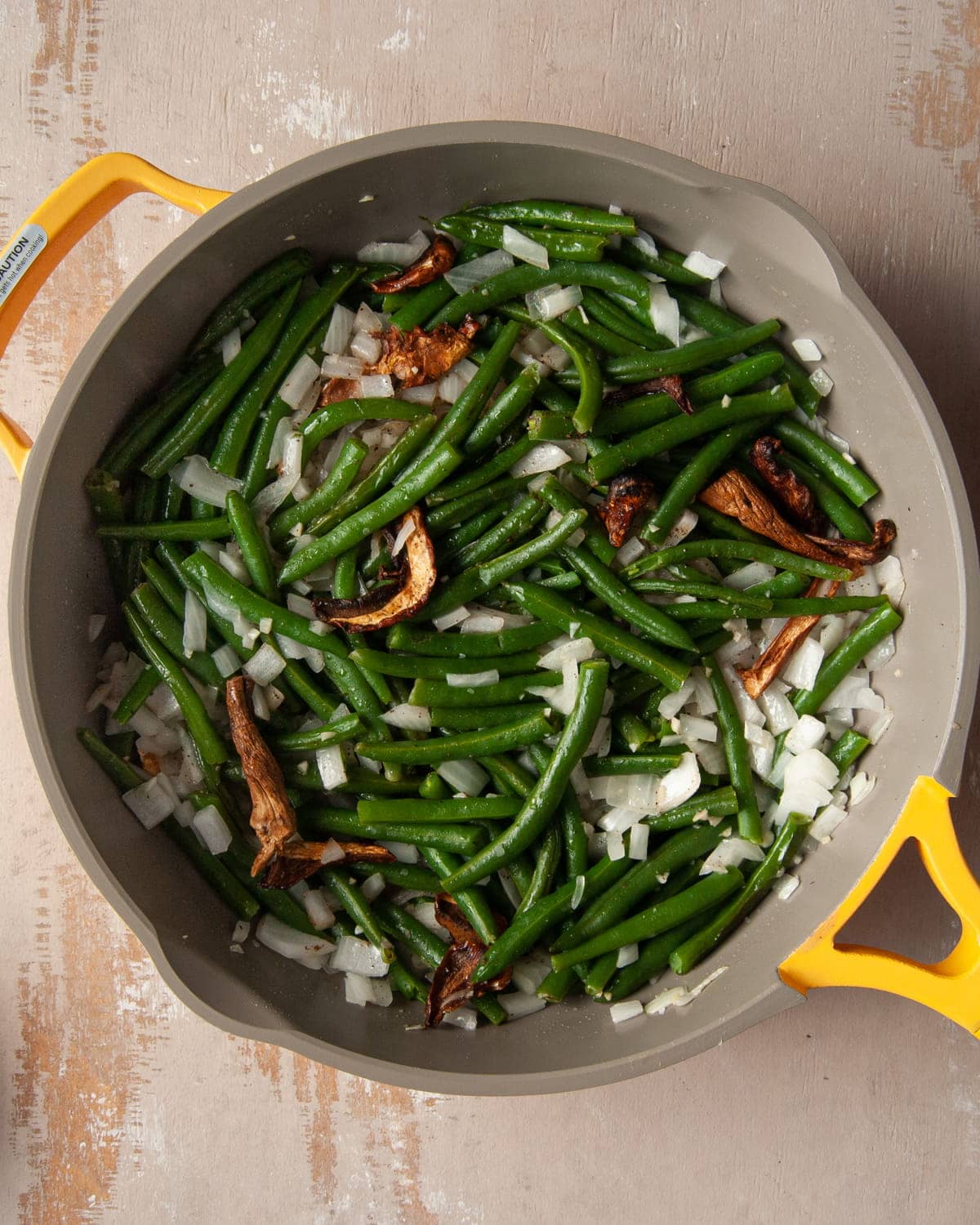 sauteeing chopped onion, minced garlic, salt, pepper, fresh green beans, and dried porcini mushrooms