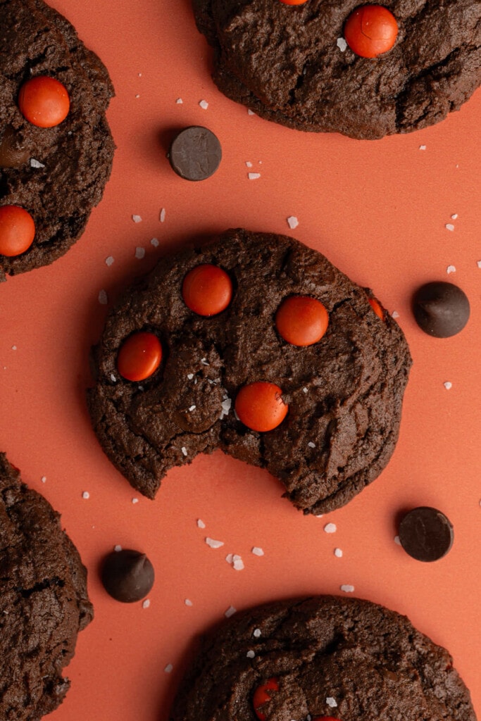 Overhead image of Double Chocolate Halloween M&M Cookies with one having bite taken out