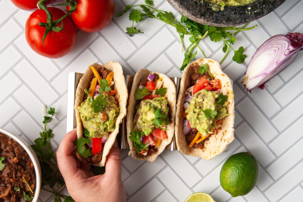 hand grabbing a meatless taco with toppings