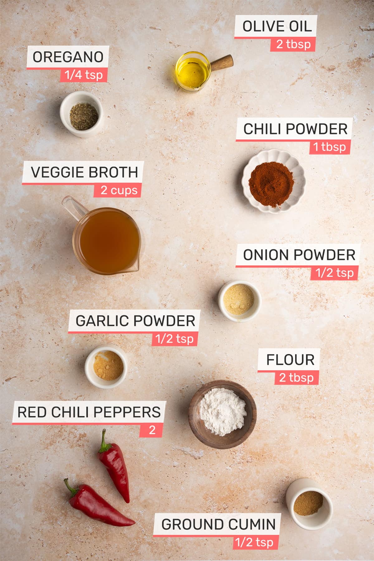 Overhead picture of all ingredients needed for Meatless Enchilada Sauce - Oregano, Olive Oil, Veggie Broth, Chili Powder, Onion Powder, Garlic Powder, Flour, Red Chili Peppers, Ground Cumin