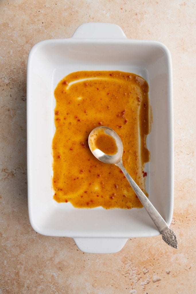 adding layer of enchilada sauce to the bottom of the baking dish