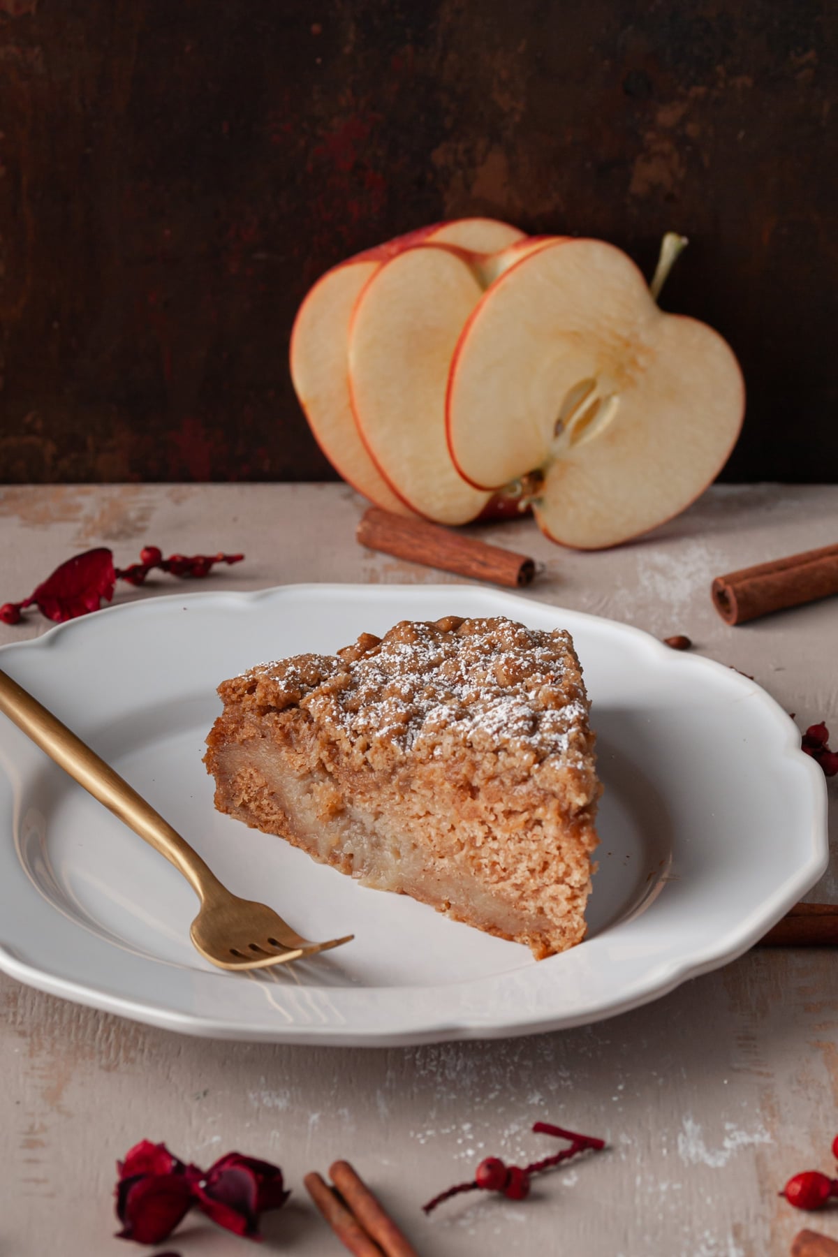 Close up of a slice of apple cake to show the super-moist texture from the fresh apples baked inside and the crumbly top.