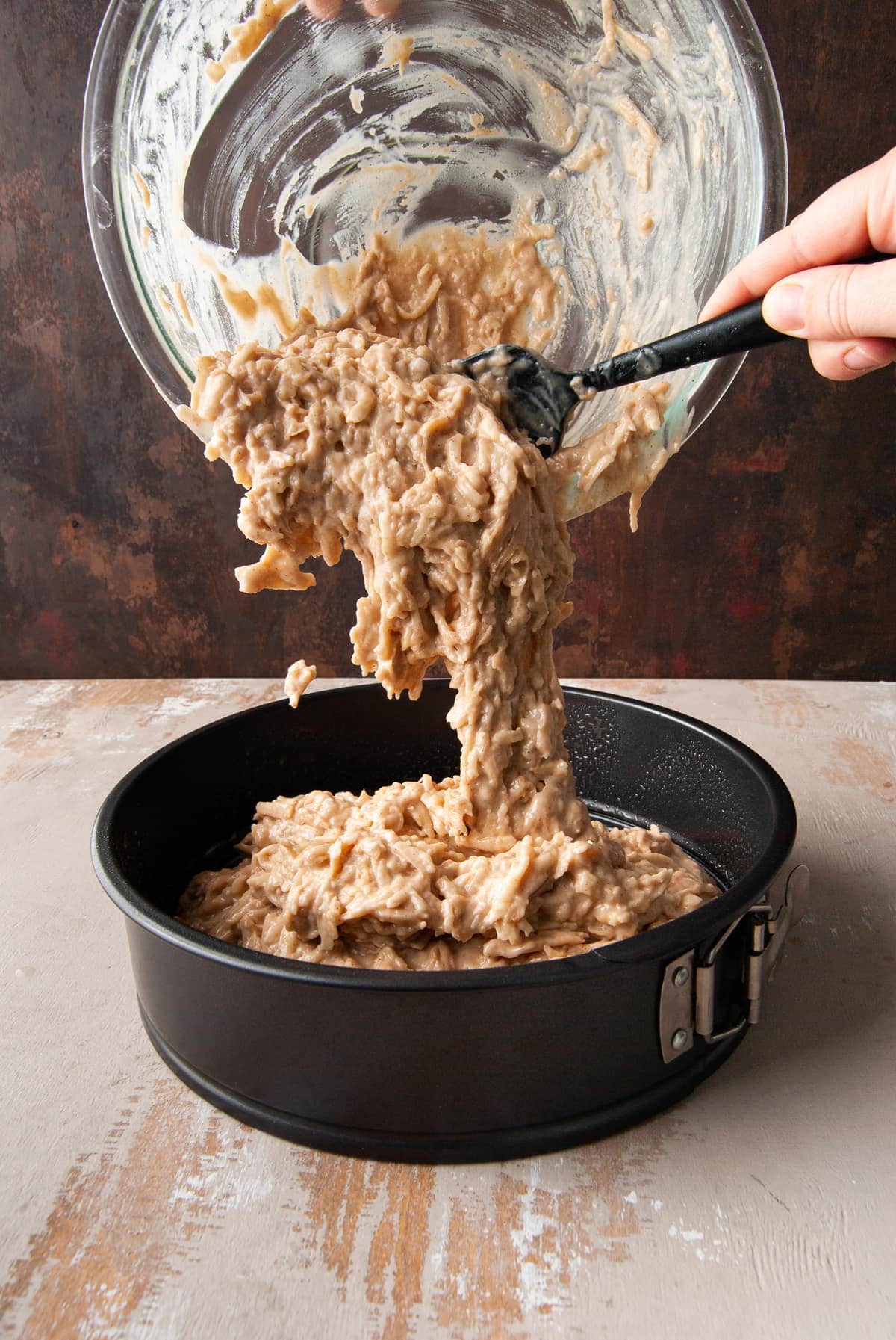 adding cake batter to a springform pan