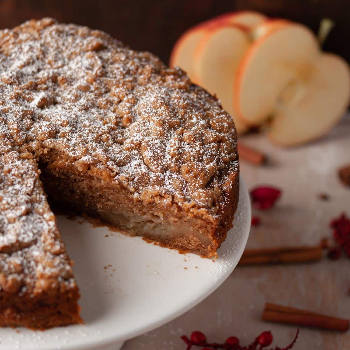 close up image of vegan apple cake with slice taken out to reveal moist inside of cake