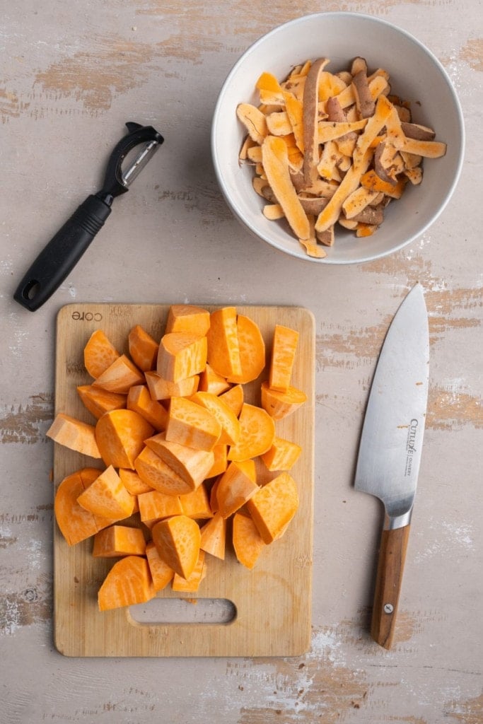 peeling and chopping sweet potatoes into chunks