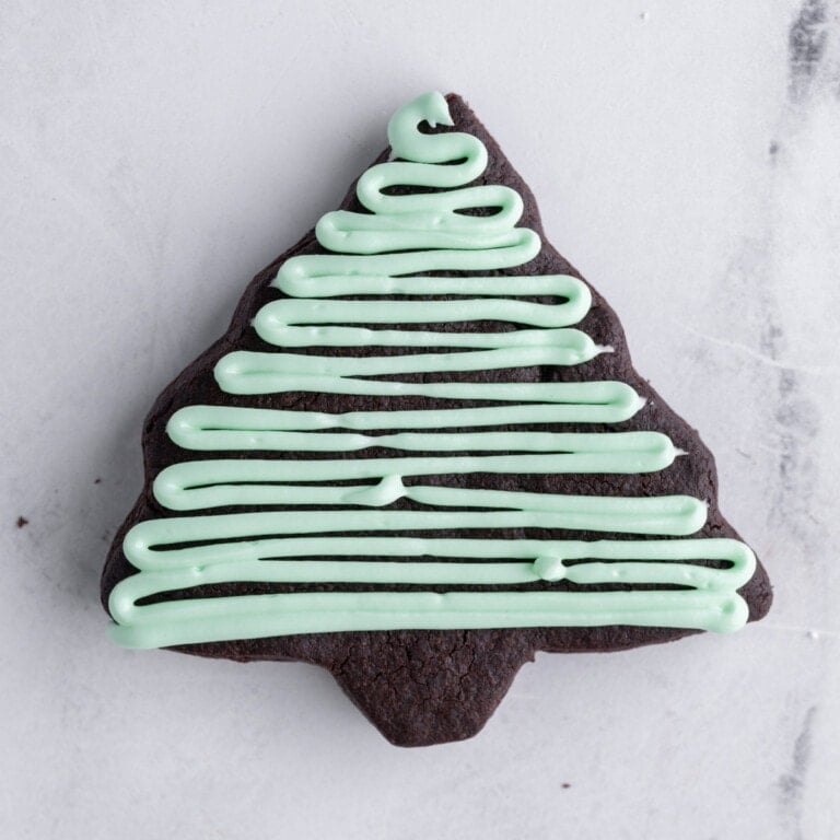 piping horizontal lines onto Christmas tree cookie