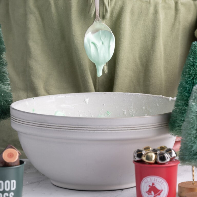 green royal icing dripping off a spoon