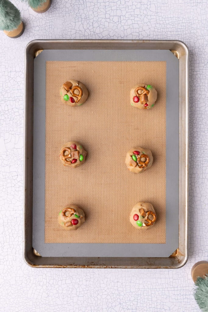 Kitchen sink Christmas cookie dough lined up on a baking sheet ready to be baked in the oven.