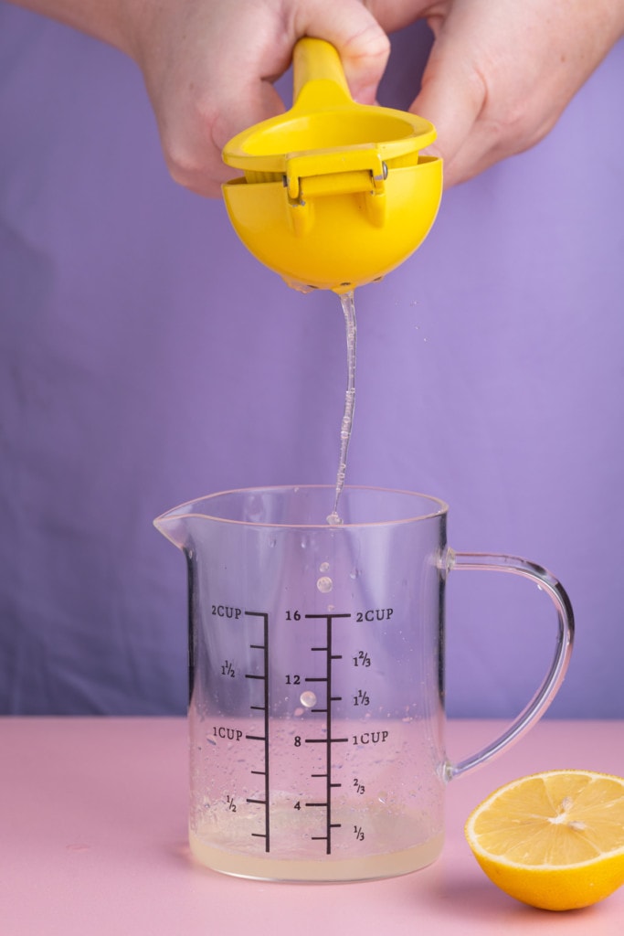 Squeezing lemon juice into a measuring cup