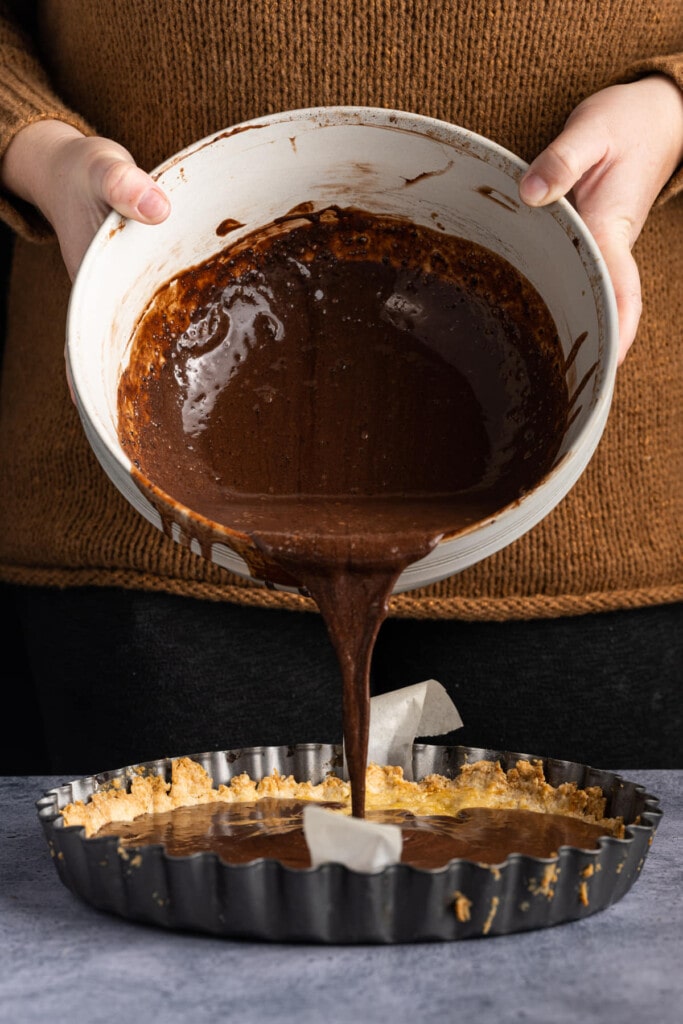 Pouring Baileys hot chocolate filling into tart crust
