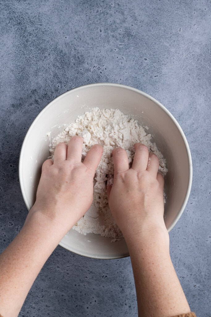 Using clean hands to mix crust ingredients