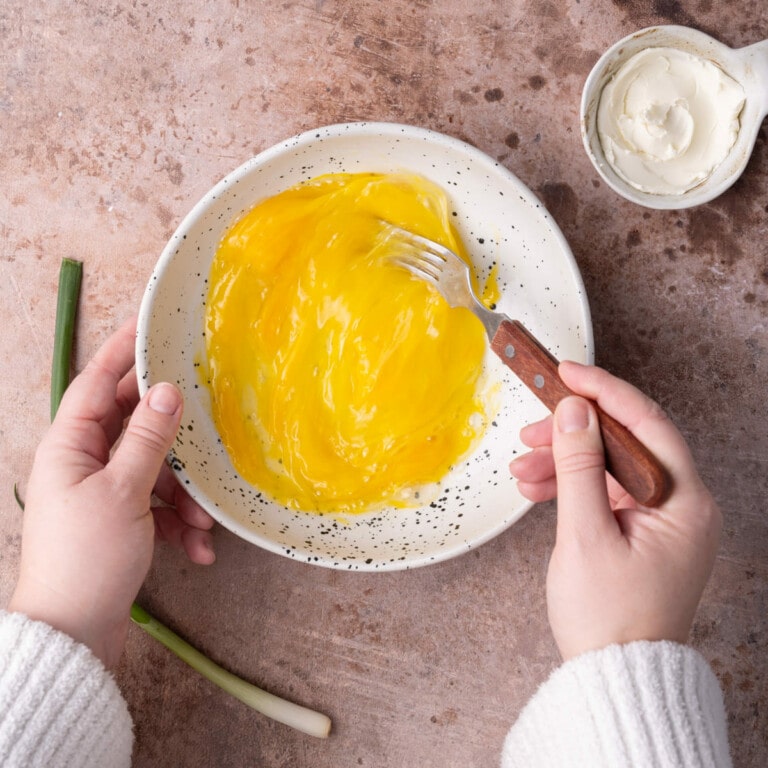 Beating eggs in a bowl with a fork