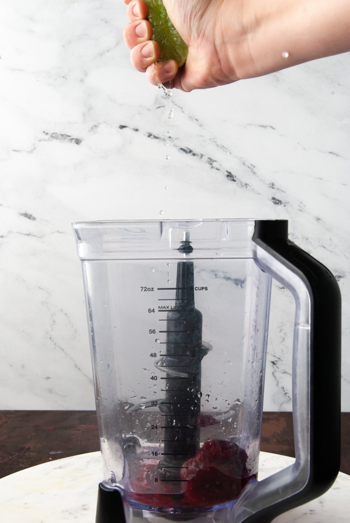 squeezing lime juice into a blender