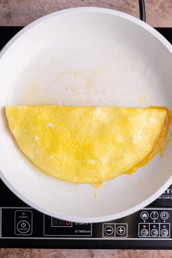 Omelet folded over in pan.