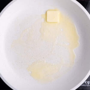 Getting butter hot and melted in a pan before adding eggs.