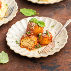 3 meatless chickpea meatballs stacked on each other on a plate