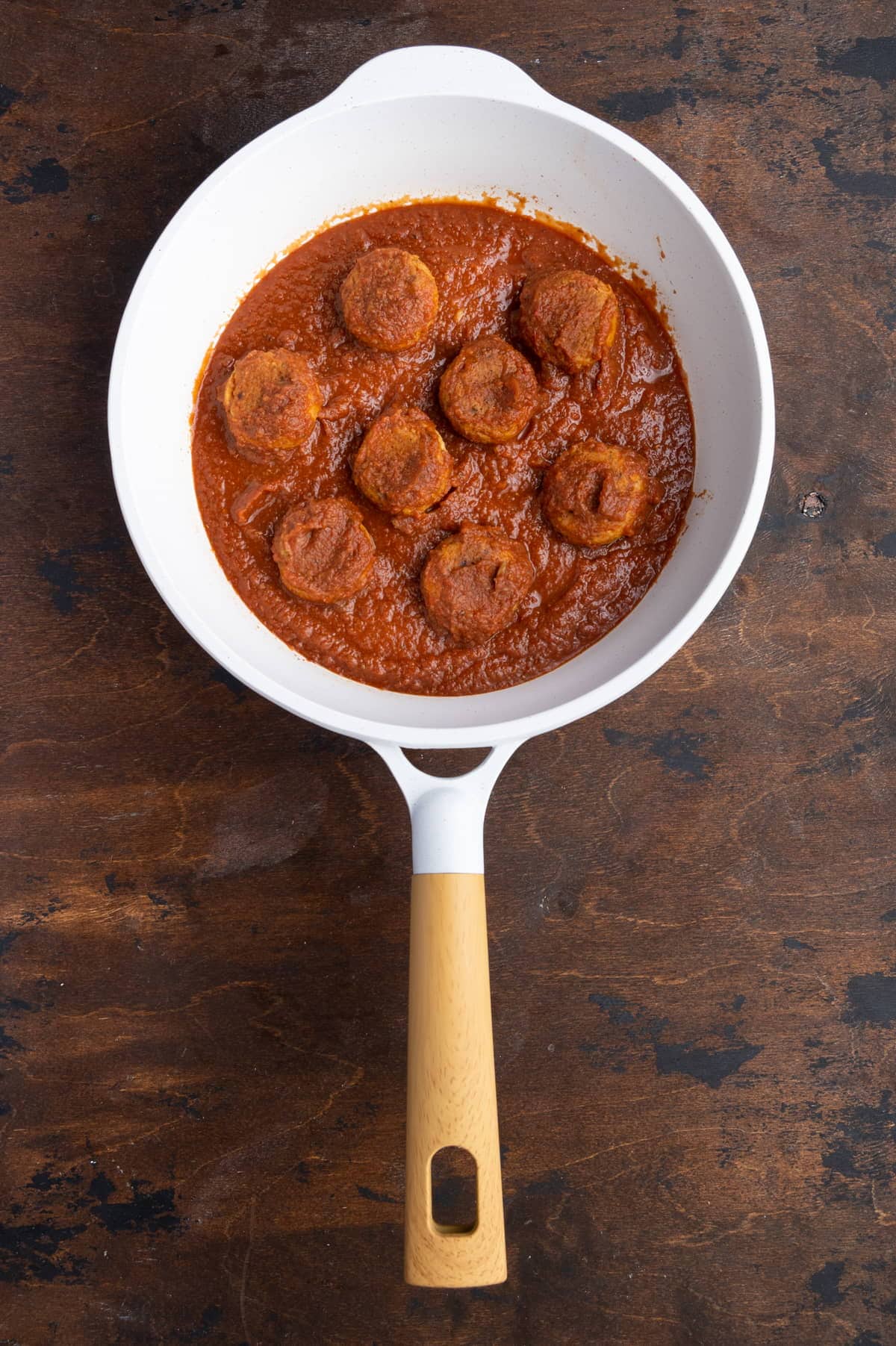 coating the meatless chickpea meatballs in sauce
