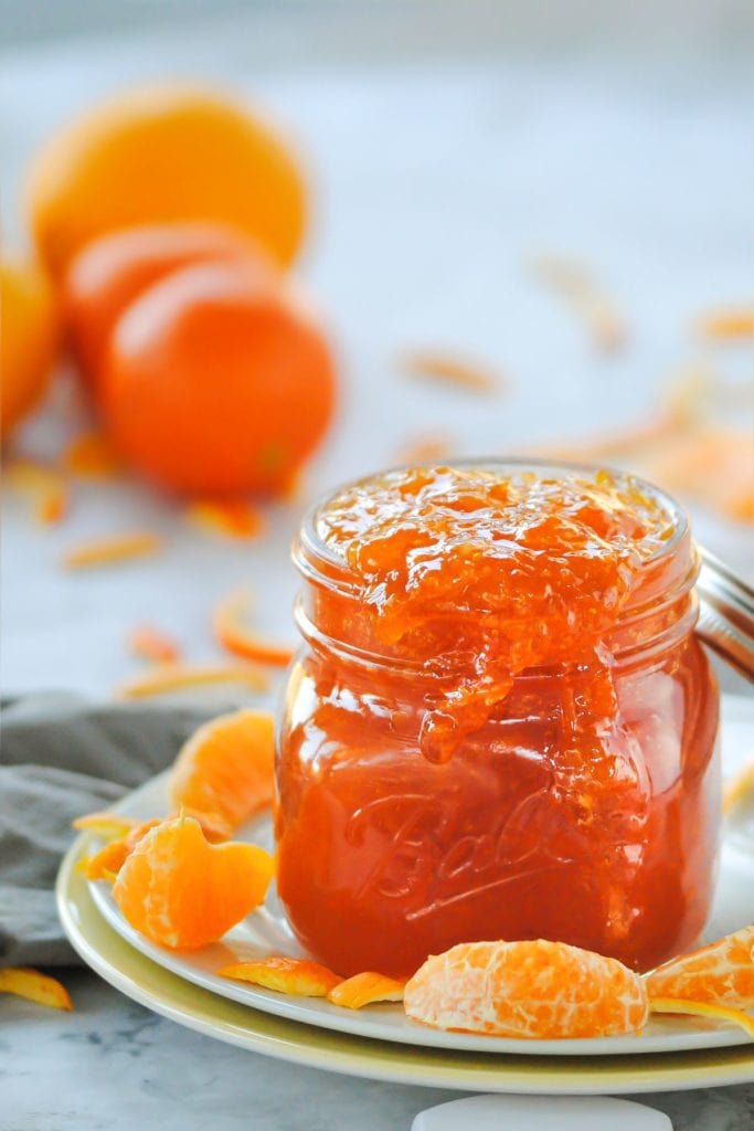 close up of jar with orange marmalade dripping out