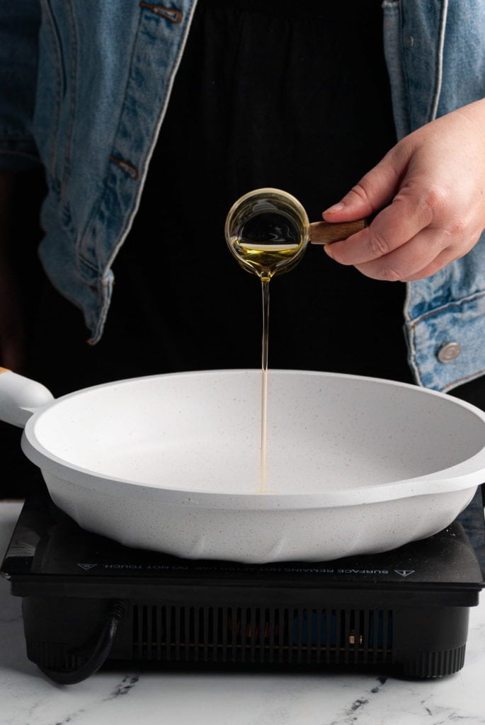 adding olive oil to nonstick pan to get hot before adding shrimp to blacken