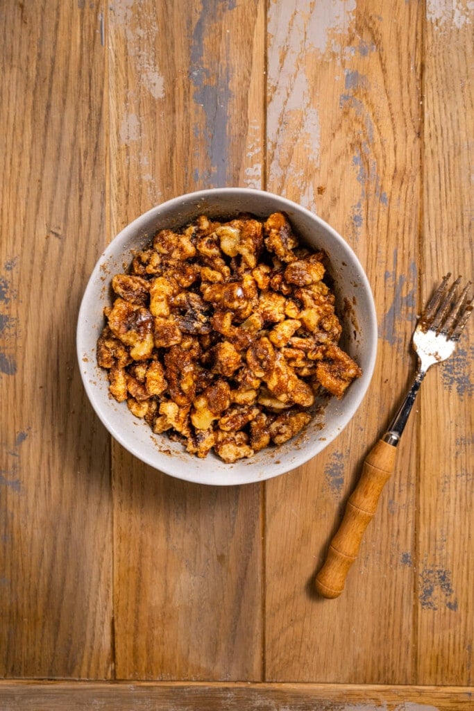 Tossing egg white coated walnuts in cinnamon sugar mixture