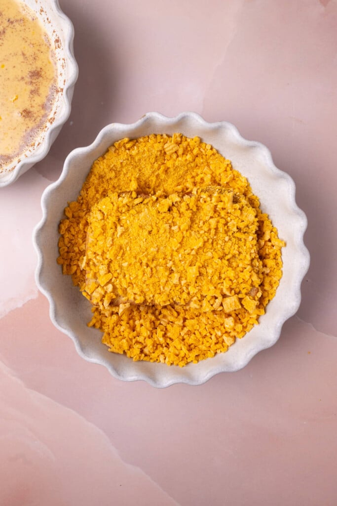 Sliced brioche covered in egg wash and completely coated on both sides with crushed cereal.
