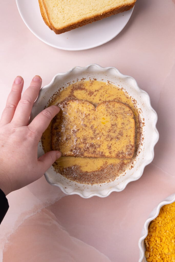 Slice of brioche bread completely coated on both sides with cinnamon egg wash. 
