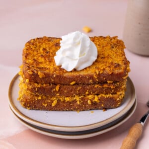 3 slices of Cap'n Crunch French toast topped with whipped cream.
