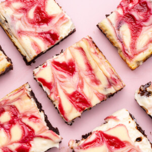 Fudgy brownies with a cheesecake layer with a vibrant raspberry swirl.