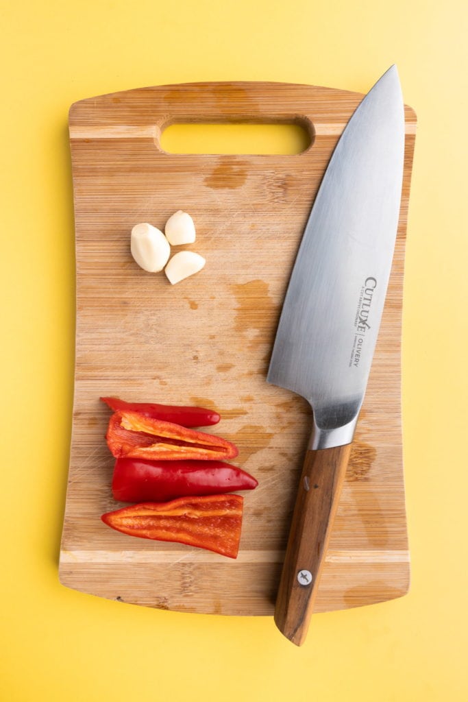 peeling garlic and slicing into peppers