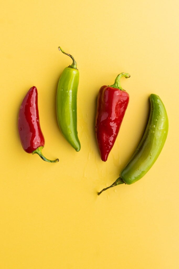 two red serrano peppers and two green serrano peppers