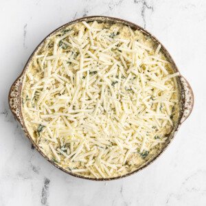 Adding vegan mozzarella cheese on top of Vegan Spinach Artichoke Dip