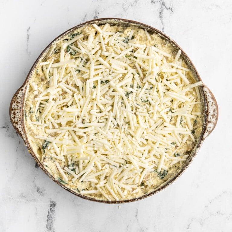 Adding vegan mozzarella cheese on top of Vegan Spinach Artichoke Dip