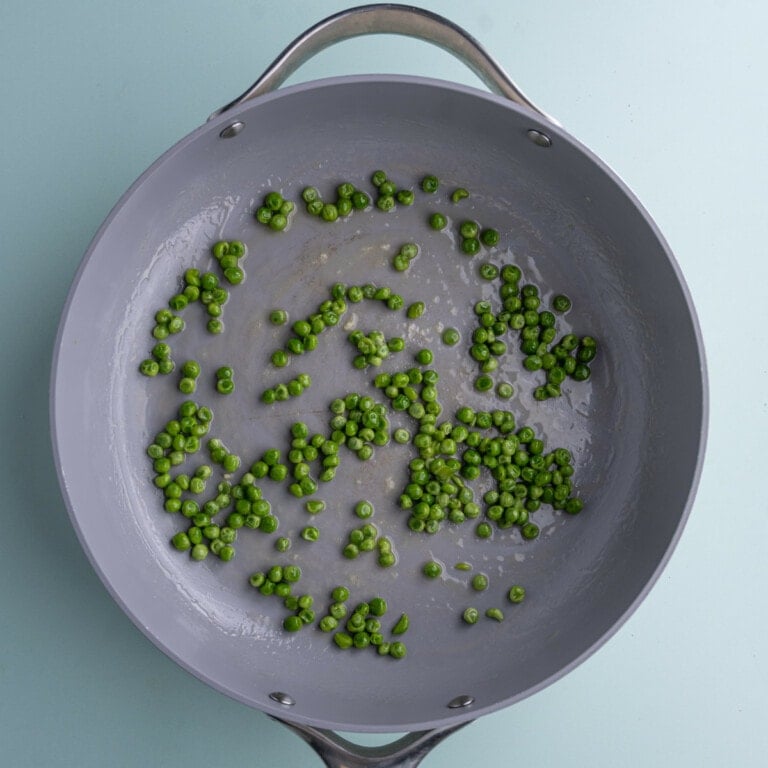 Peas in a pan frying in butter and sugar