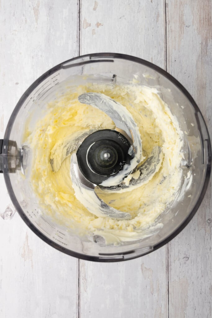 Blending minced garlic, softened butter, and garlic salt together to make garlic compound butter.