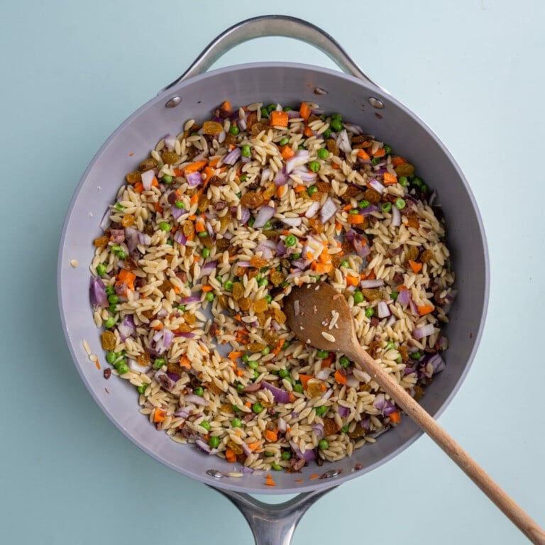 Tossing all Rainbow Orzo Salad ingredients together
