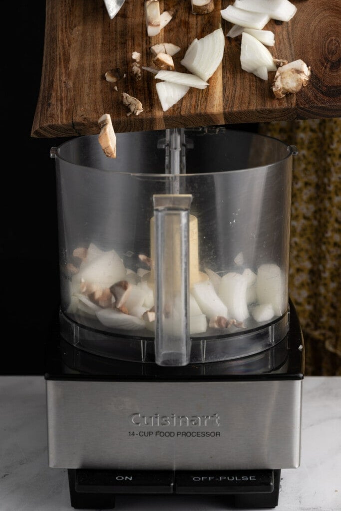 Adding ingredients for Vegan Sausage Patties to the food processor