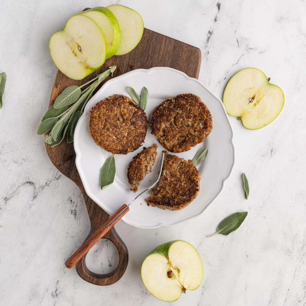 Vegan Sausage Patties for Breakfast surrounded by apples and sage
