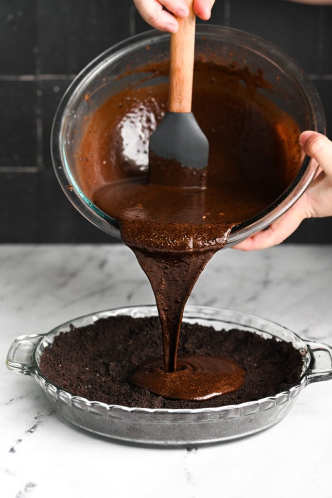 pouring chocolate mint pie filling into Oreo crust