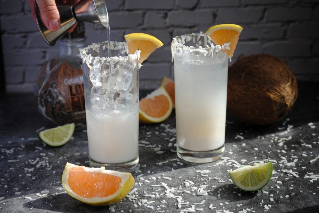 Pouring Coconut Water into glass of coconut rum