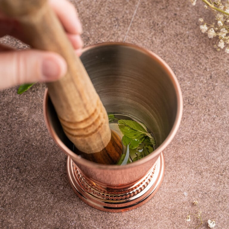 Muddling mint to extract maximum flavor