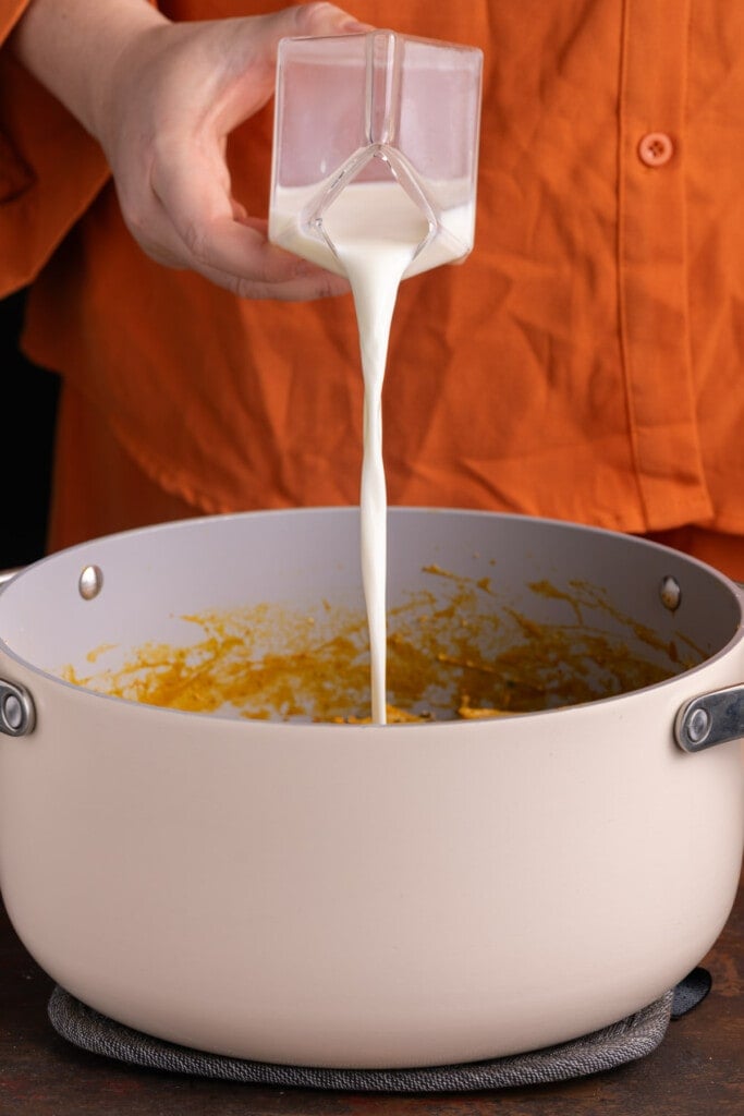 Thinning out pumpkin pasta sauce with milk.