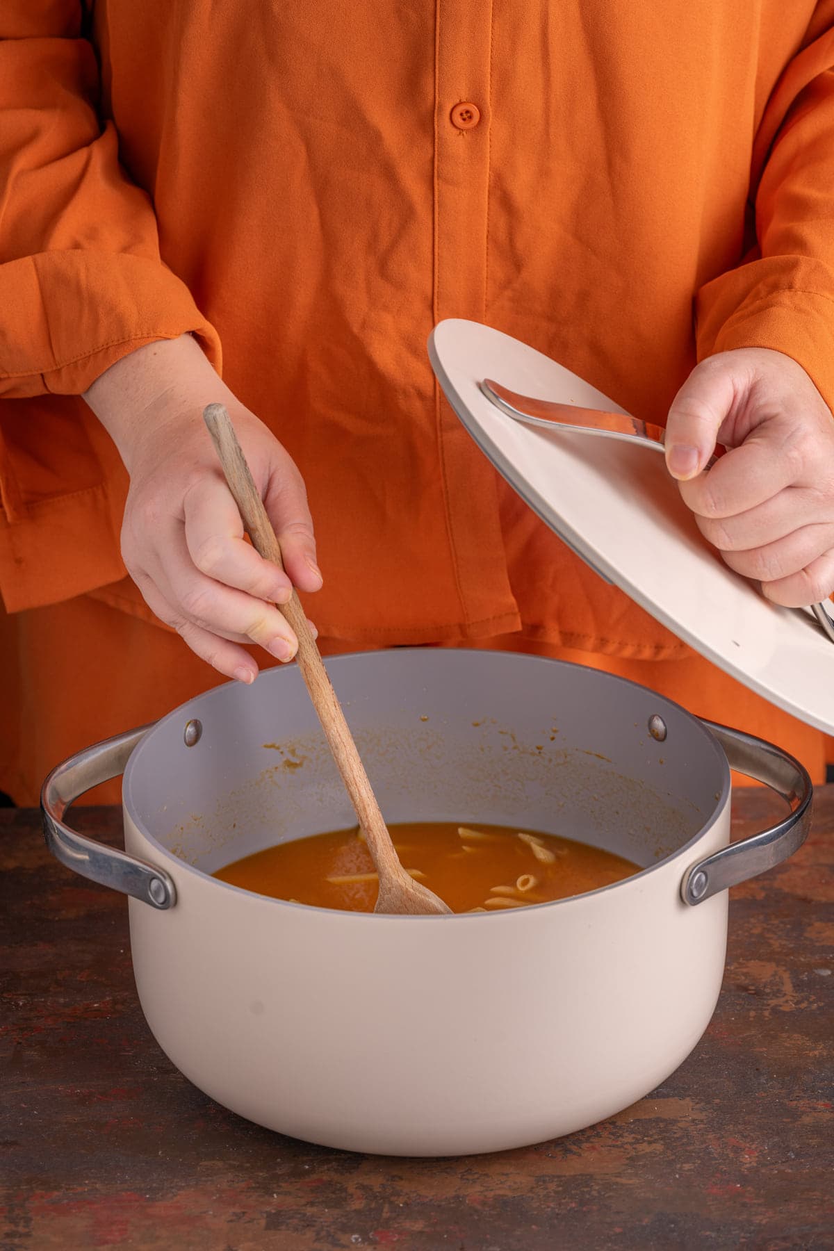 Stirring one pot pasta with pumpkin sauce as it cooks to avoid sticking