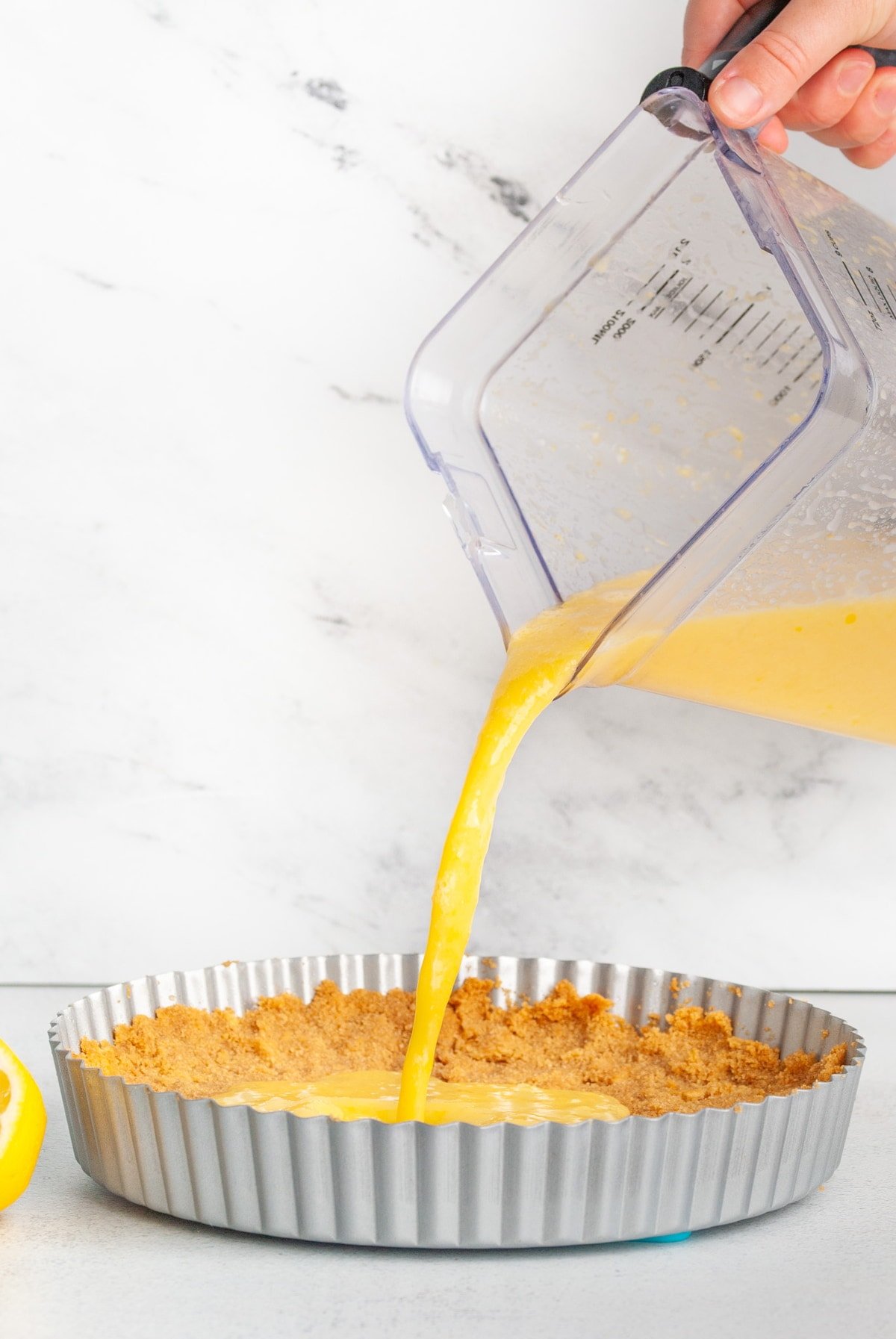 pouring pineapple pie filling into graham cracker crust