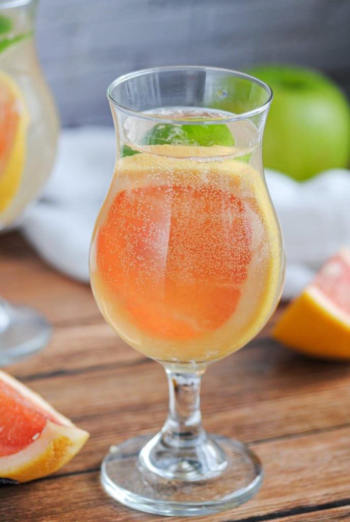 close up of sangria glass with slice of grapefruit and bubbly liquid inside