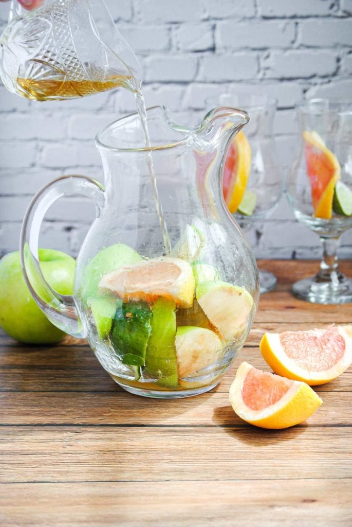 pouring dark rum into a glass pitcher