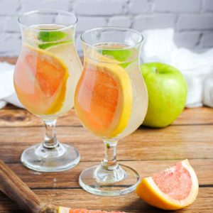 two glasses of white wine sangria with an apple and grapefruit slices