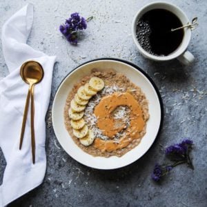 breakfast of porridge with peanut butter and bananas and cofee