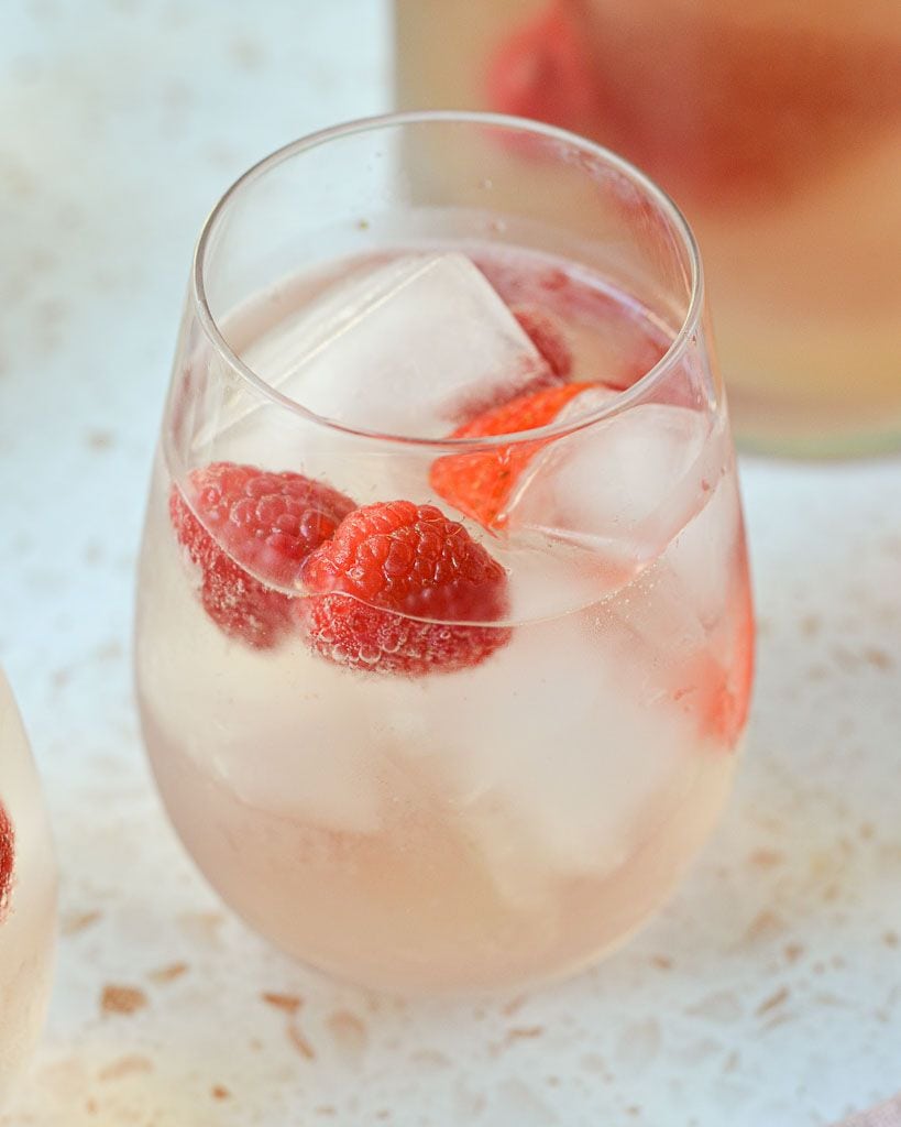 stemless wine glass filled with sparkling rose and strawberries